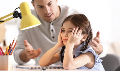 Un parent et son enfant face à des devoirs
